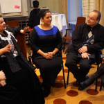 Romska deltagare på konsultationen sitter och diskuterar i en ring i ett konferensrum.